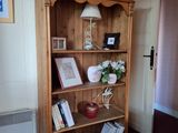 une bibliothèque en bois avec des livres dessus, dans une pièce