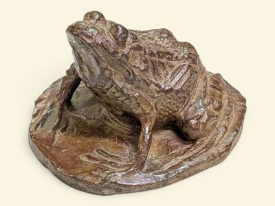 une statue représentant une grenouille assise sur une feuille