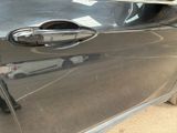 a close up of a car door handle with a car in the background