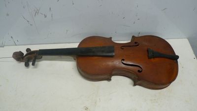 un vieux violon posé sur une table près d'un mur