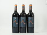 trois bouteilles de vin rouge posées sur une table blanche