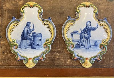une paire de plaques en faïence de Delft bleues et blanches représentant un homme et une femme