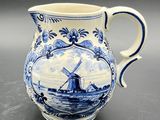 an old blue and white pitcher with a windmill on it