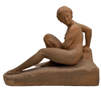 statue of a woman sitting on a rock with her legs crossed