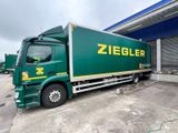 a large green truck parked in front of a building