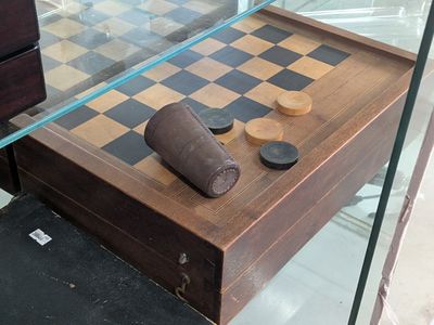 a glass case with a chess board and pieces of wood on it