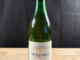 une bouteille de vin blanc posée sur une table en bois