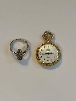 deux bagues et une montre de poche posées sur une table