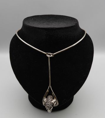 un mannequin noir portant un collier en argent