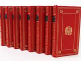 six red books lined up in a row on a white surface