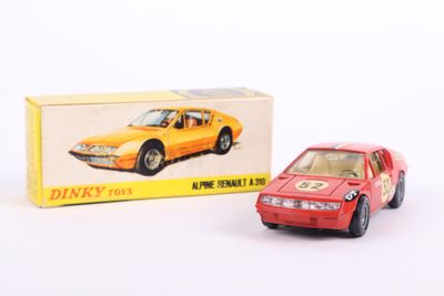 a red toy car sitting next to a box of dinky toys