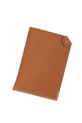 un étui à passeport en cuir marron muni d'un bouton sur le devant