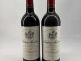 deux bouteilles de vin rouge posées l'une à côté de l'autre sur une surface blanche