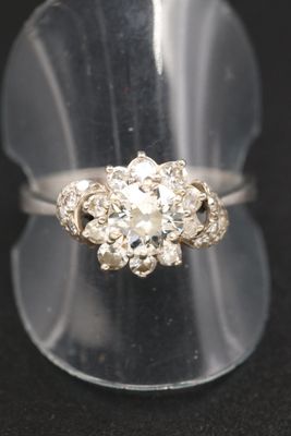 une photo en gros plan d'une bague en diamant posée sur un présentoir transparent