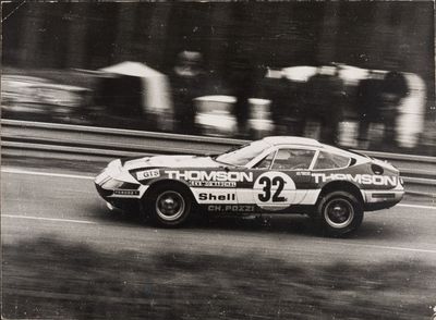 a black and white photo of a race car on the track