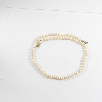 collier de perles avec un fermoir en or sur fond blanc