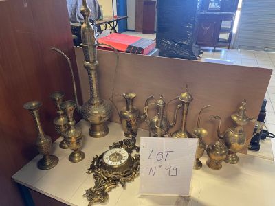 une table sur laquelle sont posés de nombreux objets en laiton