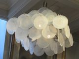 a chandelier made out of plastic plates hanging from the ceiling