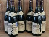 plusieurs bouteilles de vin sont alignées sur une étagère en bois