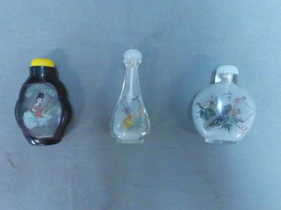 trois petites bouteilles en verre posées les unes à côté des autres sur une table