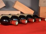 several bottles of wine are lined up on a red table