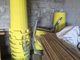 un tas de bois dans une pièce où se trouve un poteau jaune