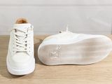 a close up of a pair of white sneakers on a wooden table