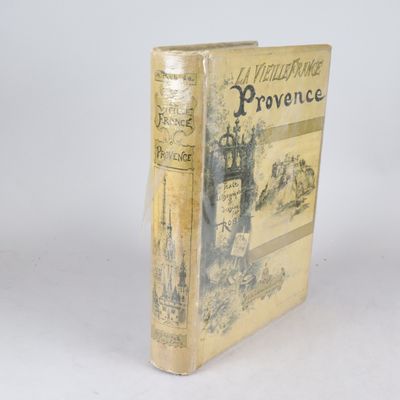 un vieux livre posé sur une table blanche à côté d'un mur blanc