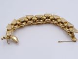 an image of a gold bracelet on a white surface