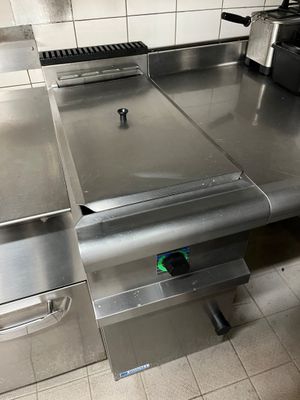 plan de travail en acier inoxydable dans une cuisine commerciale équipée d'appareils en acier inoxydable