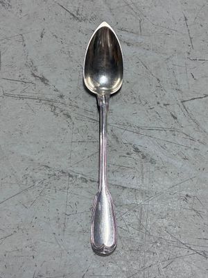une cuillère en argent avec un manche de cuillère sur une table