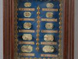 une image représentant une photo d'un tableau encadré montrant un ensemble de pièces de monnaie
