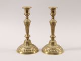 pair of antique brass candlesticks on a white background