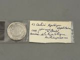 une photo d'une pièce de monnaie à laquelle est attaché un bout de papier