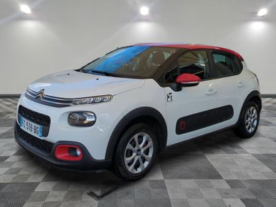 une voiture blanche de marque Citrole garée dans une pièce au sol en damier