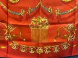 a red and gold scarf with gold decorations on it