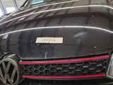 a close up of a black car with a red stripe on it