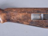 an old wooden rifle with a metal handle on a gray surface
