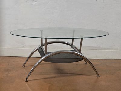 a glass table with a magazine rack underneath it