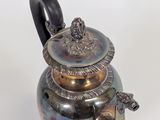 a silver tea pot with a handle on a white background