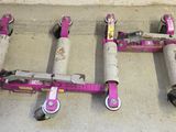 four pink scooters that are sitting on the ground