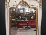 a mirror that is sitting on the floor in front of a red couch