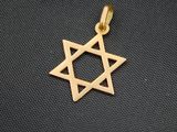 un pendentif représentant une étoile de David dorée sur fond noir