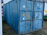 un grand conteneur bleu posé au milieu d'une cour