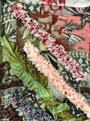 un gros plan d'une couette en patchwork ornée de fleurs et de papillons