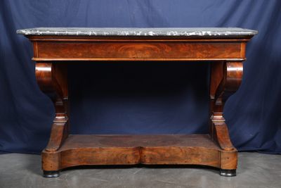 an old wooden table with a marble top on a blue background