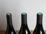 four bottles of wine are lined up on a wooden table