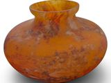 an orange vase that is sitting on a white surface