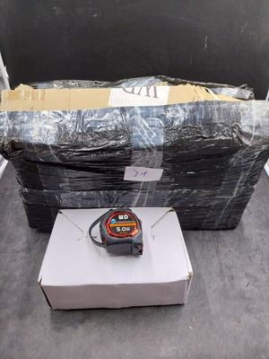 une pile de cartons et un carton sur lequel est posé un mètre ruban