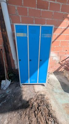 un casier bleu devant un mur de briques